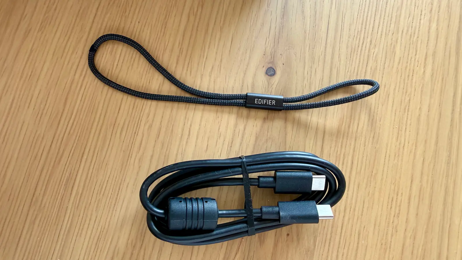 Dragonne noire Edifier et câble USB-C vers USB-C fournis avec l’enceinte ES60