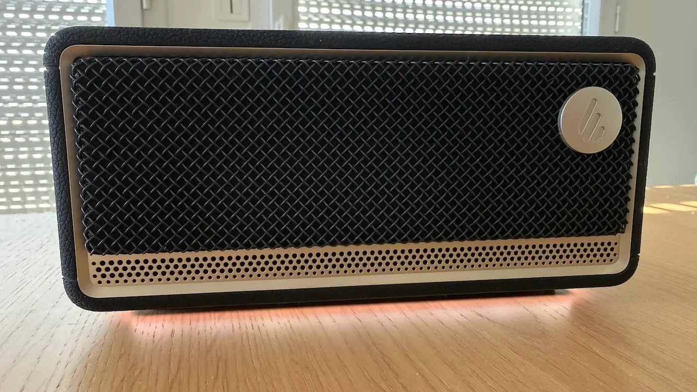 Éclairage d’ambiance jaune sous l’Edifier ES60 posée sur une table en bois