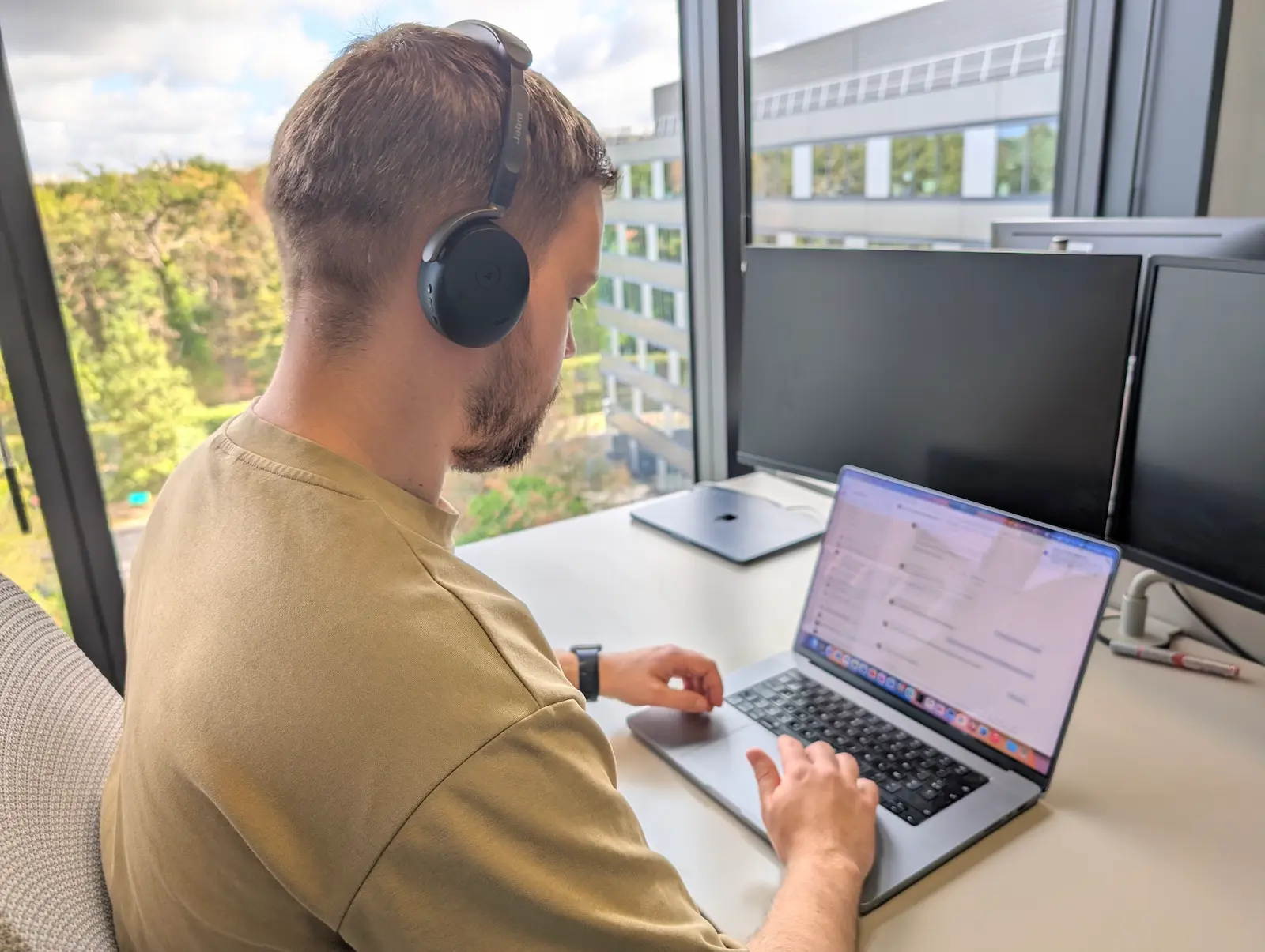 Jabra Evolve3 65 Flex porté au bureau devant un MacBook Pro
