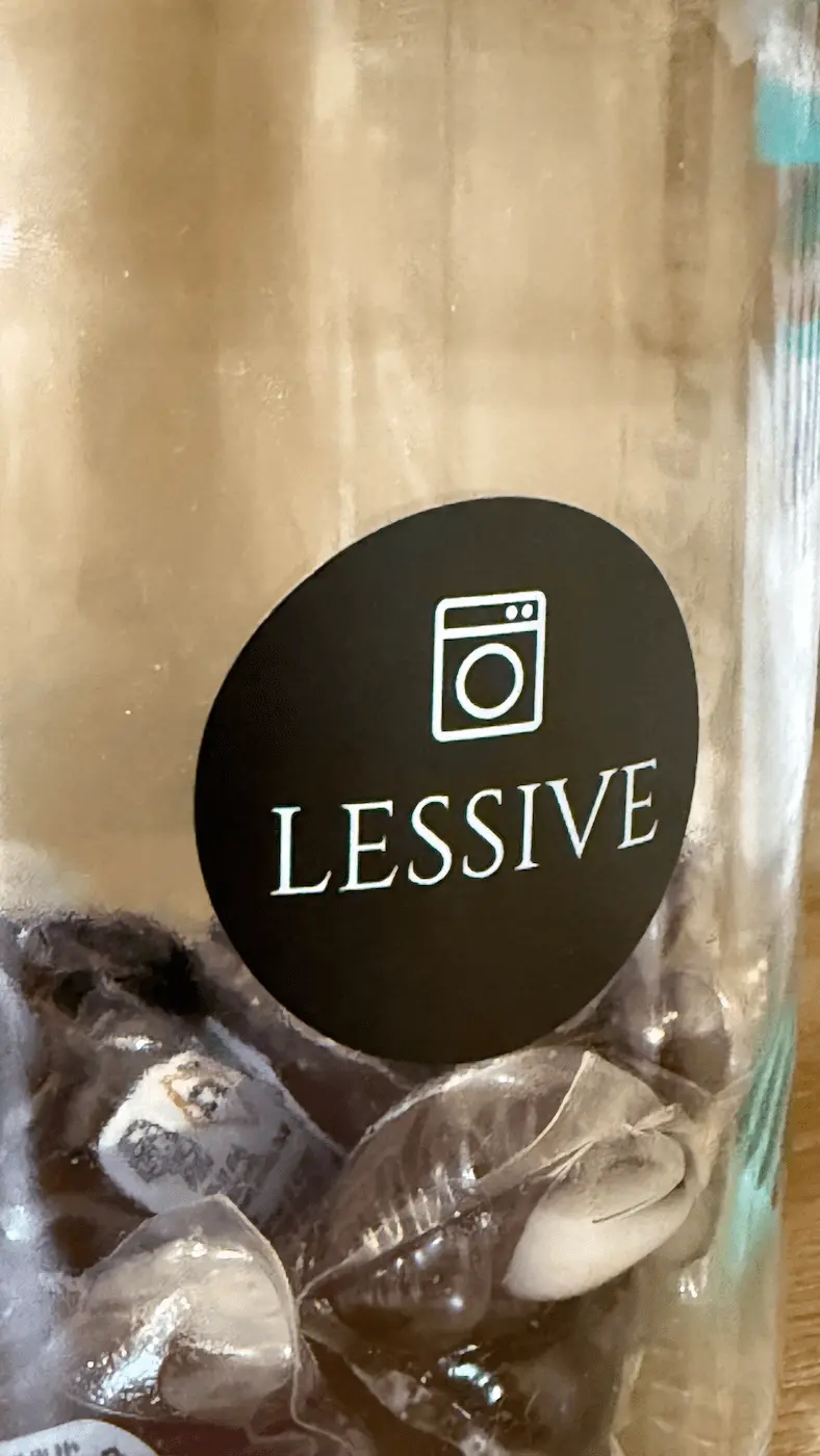 Étiquette ronde noire Lessive avec une écriture blanche et une icône de machine à laver